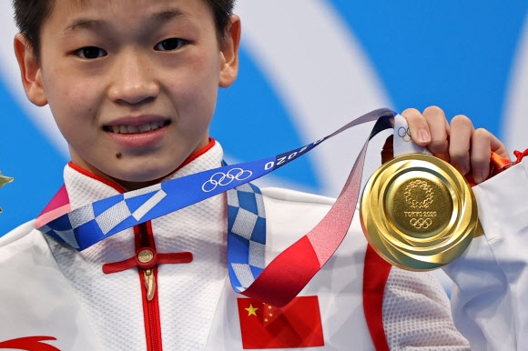 중국의 취안훙찬 선수가 5일 2020 도쿄올림픽 여성 다이빙 10m 플랫폼 종목에서 딴 금메달을 들어보이고 있다. 로이터 연합뉴스