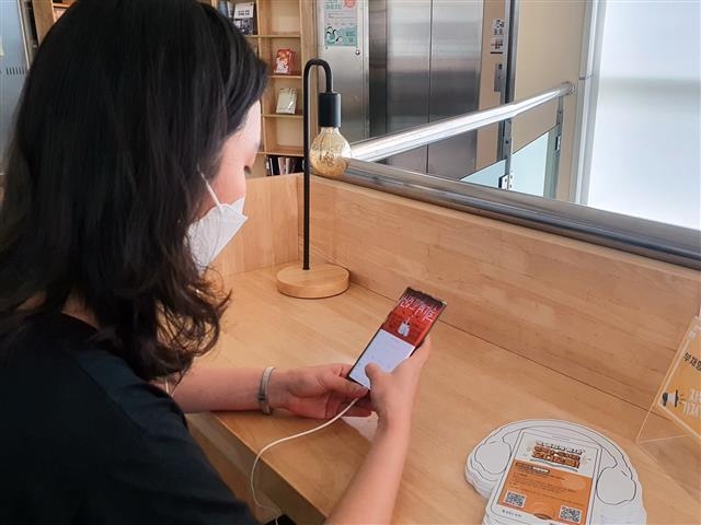 서울 성북구의 한 주민이 스마트폰을 통해 오디오북 프로그램을 살펴보고 있다. 성북구 제공