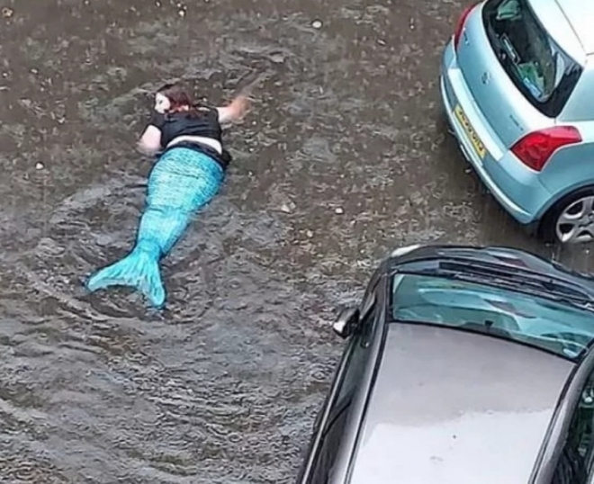 홍수로 도로 침수됐는데 인어공주 수영복 입고 물놀이 하는 여성. ‘더 미러’ 캡처