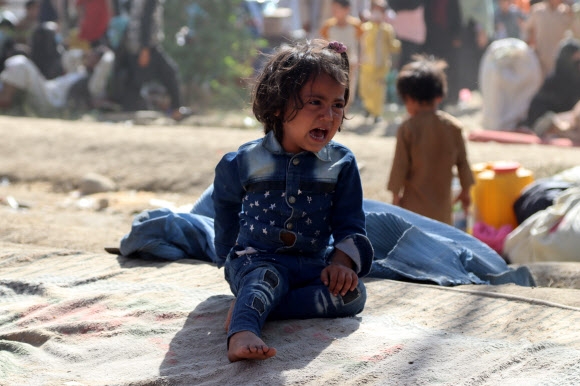 아프가니스탄의 한 어린이가 10일(현지시간) 수도 카불에 마련된 임시 난민 수용지에 주저앉아 울고 있다. 탈레반과 정부군 간 치열한 전투가 진행 중인 가운데 반탈레반 성향이 강했던 쿤두즈와 타크하르주 등 북부 지역이 탈레반 수중으로 넘어가면서 피란민이 대거 발생하고 있다. 특히 유엔아동기금에 따르면 지난 사흘간 교전으로 최소 어린이 27명이 숨지고 136명이 다쳤다. 카불 EPA 연합뉴스