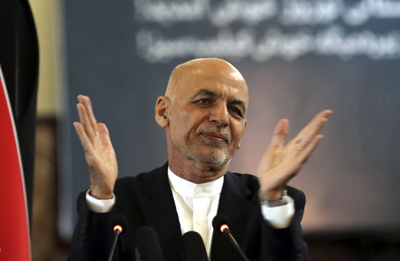 국외로 탈출한 사실이 확인된 아슈라프 가니 아프가니스탄 대통령이 페르시아력으로 새해 첫날인 지난 3월 21일(현지시간) 대통령궁에서 손뼉을 마주 치며 축하하고 있다. AP 자료사진 연합뉴스