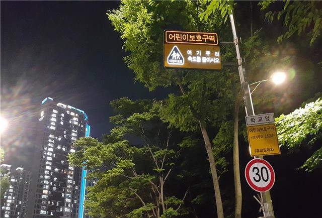서울 강덕초등학교 인근에 야간에도 환하게 빛나는 친환경 태양광 발광다이오드(LED) 표지판이 설치된 모습. 강동구 제공