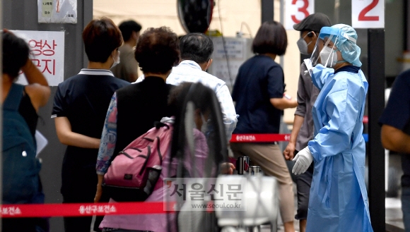 18일 서울 용산구청에 마련된 선별진료소를 찾은 시민들이 코로나19 검사를 위해 줄을 서 있다. 2021.8.18 박지환기자 popocar@seoul.co.kr