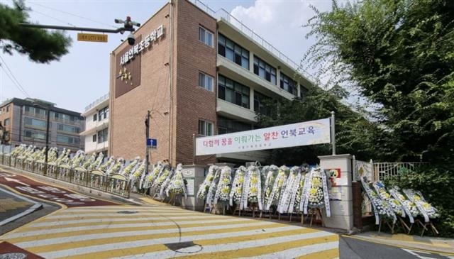 지난달 말 서울 강남의 한 초등학교 입구에 그린스마트 미래학교에 반대하는 학부모들이 설치한 조화가 빽빽하게 늘어서 있다. 페이스북 캡처