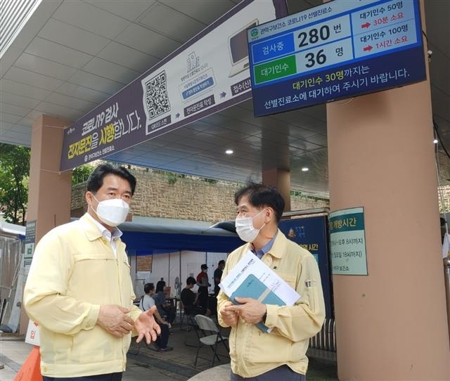 서울 관악구보건소 선별진료소 앞에 설치된 전광판 앞에서 박준희(왼쪽) 관악구청장이 직원과 이야기를 나누고 있다. 관악구 제공