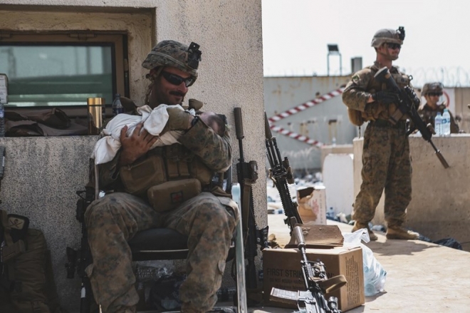 카불 공항 내에서 아기를 돌보고 있는 미 해병대원의 모습. 사진 속 아기의 신원은 알려지지 않았다. 사진=epa 연합뉴스
