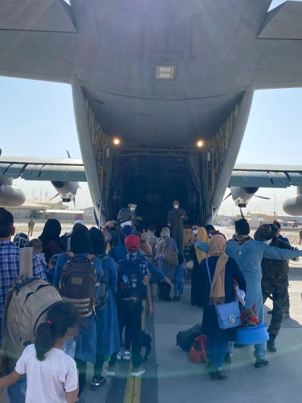 한국 정부와 협력한 아프가니스탄인들이 국내 이송을 위해 카불 공항에 도착한 한국 공군 수송기에 오르고 있다. 2021.8.25  외교부 제공