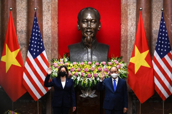카멀라 해리스(왼쪽) 미국 부통령이 25일 베트남의 하노이 대통령궁의 호치민 동상 앞에서 응우옌 쑤언 푹 대통령과 사진을 찍고 있다. AFP 연합뉴스
