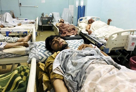 26일(현지시간) 아프가니스탄 수도 카불 공항 외곽에서 발생한 연쇄 자살폭탄 테러로 부상한 시민들이 인근 병원으로 옮겨져 침상에 누워 있다.  AP 연합뉴스