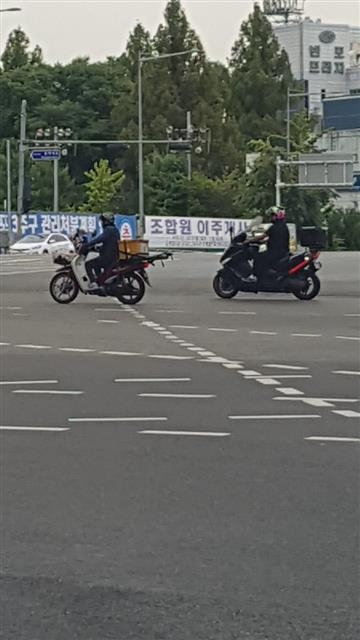지난 29일 서울 동작구 이수교차로에서 오토바이 2대가 신호 대기를 무시하고 내닫고 있다.