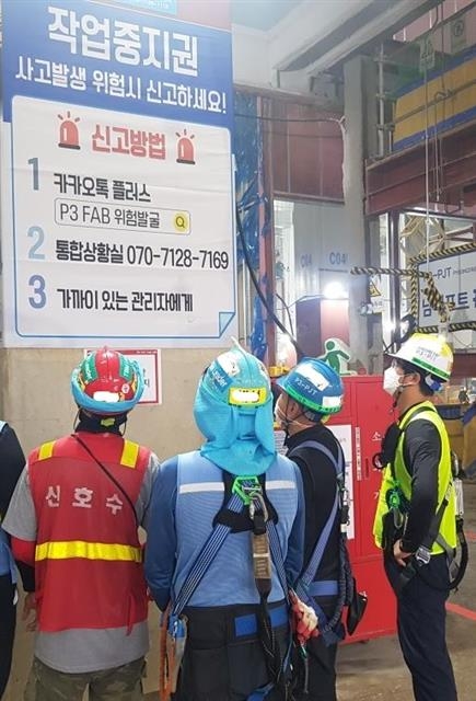 삼성물산의 한 건설현장에 내걸린 작업중지권에 대한 안내문을 근로자들이 읽고 있다. 삼성물산 제공