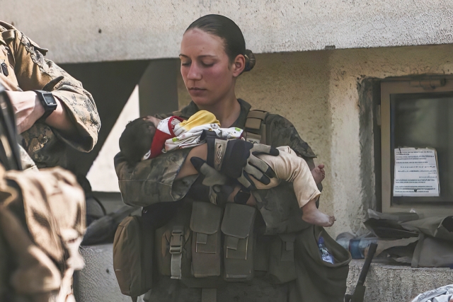 미국 해병대 소속의 니콜 지 병장이 지난 20일(현지시간) 아프가니스탄 카불 공항에서 아기를 안은 모습. 연합뉴스