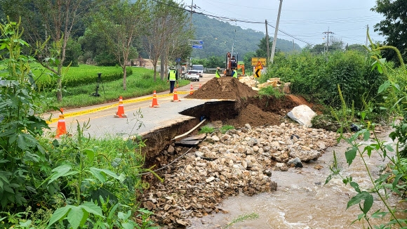 밤사이 폭우가 쏟아진 1일 홍성군 금마면에서 중장비로 파손된 도로를 복구하고 있다. 연합뉴스