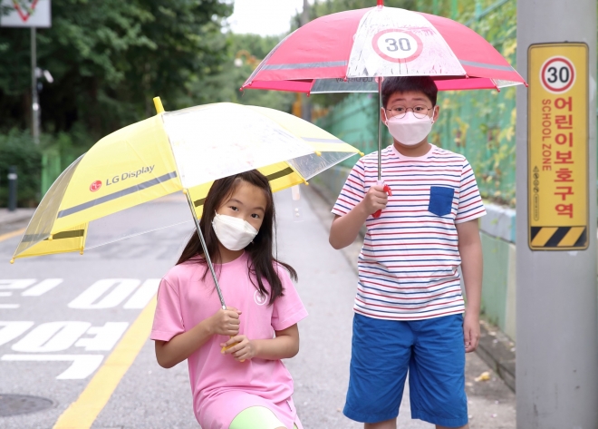 　어린이들이 LG디스플레이가 준비한 ‘투명 안전 우산’을 사용하고 있는 모습. 　LG디스플레이 제공