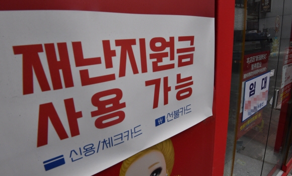 재난지원금 지급을 하루 앞둔 5일 서울 명동의 텅빈 상점에 재난지원금 사용가능을 알리는 안내문구가 붙어 있다. 2021.9.5 박지환기자 popocar@seoul.co.kr