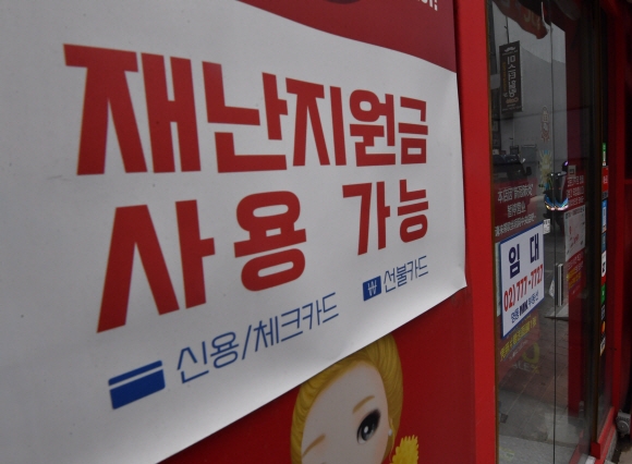 지난 5일 서울 시내 한 편의점에 ‘코로나 상생 국민지원금’ 사용처임을 알리는 홍보물이 부착돼 있다. 연합뉴스