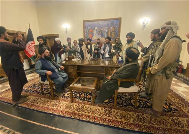 탈레반들이 지난달 16일 카불 대통령궁에서 승리를 자축하며 기념촬영을 하고 있다. 탈레반은 미국 바이든 정부가 아프간 주둔 20년 만인 지난 5월 철군을 시작하자 발 빠르게 카불을 점령했다. AP 연합뉴스