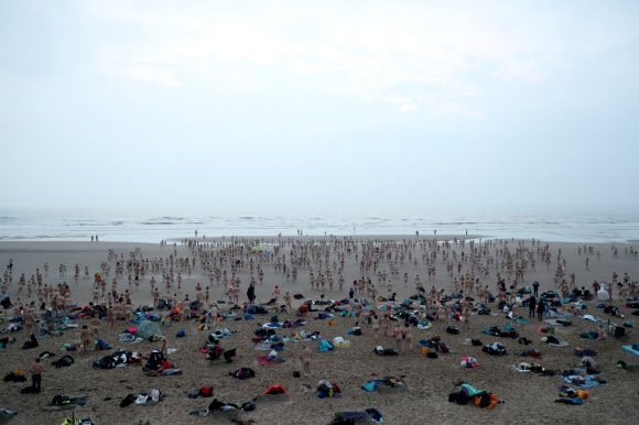 매년 열리는 노스 이스트 알몸 수영(the North East Skinny Dip)의 참가자들이 19일(현지시간) 영국 드루리지 만의 해변을 걷고 있다. 로이터 연합뉴스