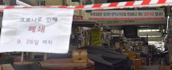 코로나19의 여파로 일부전통시장이 문을 닫은 26일 서울 중구 중부시장입구에 출입금지를 알리는 안내문구가 걸려 있다. 2021.9.26 박지환기자 popocar@seoul.co.kr
