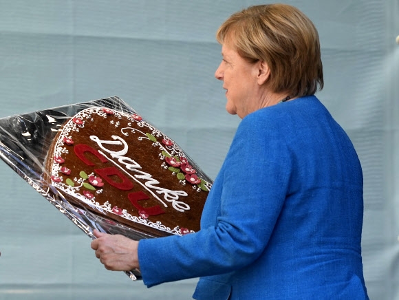 퇴임을 앞둔 앙겔라 메르켈 독일 총리가 25일(현지시간) 연방하원 총선 전 마지막 선거유세에서 ‘감사합니다 기독민주당(CDU)’이라고 적힌 케이크를 받아들고 있다.  아헨 AP 연합뉴스