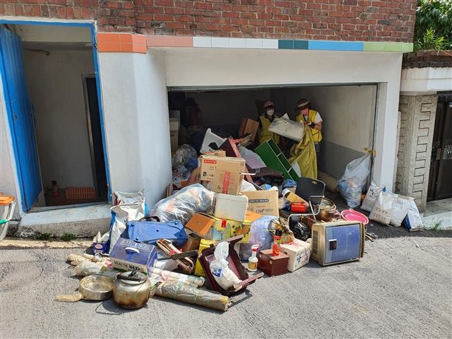 용산2가동 주민센터가 지난 11일 김칠수(가명) 노인의 쓰레기집 청소에 나섰다. 김 노인의 집에서 나온 1t 트럭 3대 분량의 쓰레기.