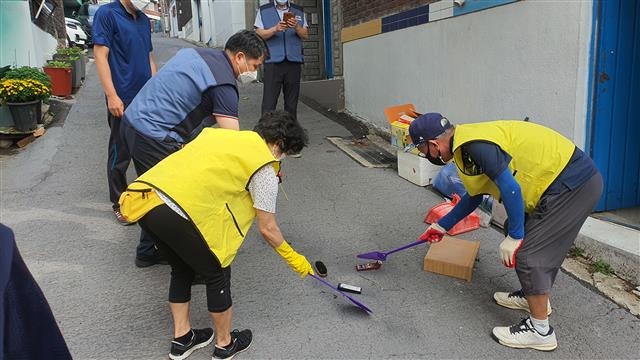 용산2가동 주민센터가 지난 11일 김칠수(가명) 노인의 쓰레기집 청소에 나섰다. 서랍에서 바퀴벌레가 수십 마리 튀어나오자 봉사자들이 황급히 바퀴벌레를 잡고 있다.