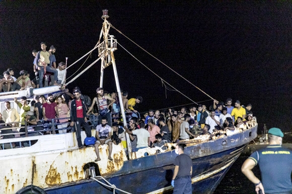 하룻밤새 이주민.난민 700여명 몰린 이탈리아 람페두사섬 27일(현지시간) 밤 아프리카 대륙과 가까운 이탈리아 최남단 람페두사섬에 이주민.난민들을 태운 낡은 어선 한 척이 정박하고 있다. 이날 686명을 태운 15m 길이의 어선이 이곳에 도착했다. 이는 지난 2016년 이래 단일 건으로는 최대 규모이며, 이 이후에도 또 다른 어선 네 척이 67명을 태우고 도착해 하룻밤 새 700명이 넘는 이주민.난민이 이곳에 발을 디뎠다. 람페두사 AP 연합뉴스