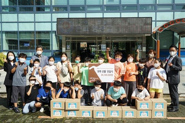 LS니꼬동제련 관계자들과 온산초등학교 학생들이 과학선물 전달식에서 단체사진을 찍고 있다. LS니꼬동제련 제공