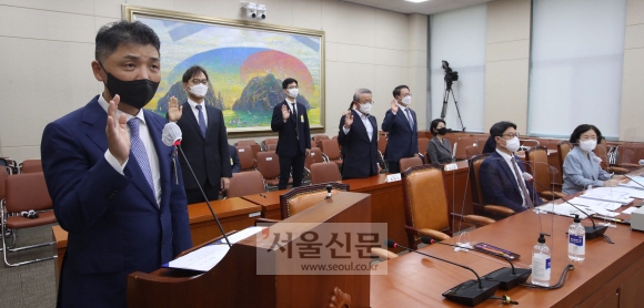김범수(왼쪽) 카카오 이사회 의장이 5일 서울 여의도 국회에서 열린 정무위원회 국정감사에 출석해 증인 선서를 하고 있다. 김 의장의 국감 출석은 두 번째로, 2018년 이후 3년 만이다. 정연호 기자 tpgod@seoul.co.kr