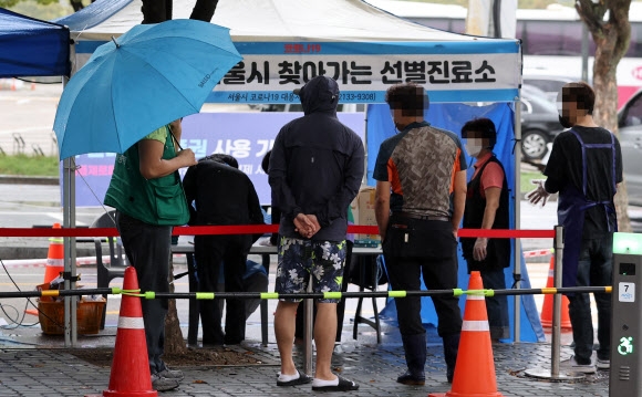 6일 오전 집단감염이 발생한 서울 마포구 마포농수산물시장 앞에 설치된 찾아가는 선별검사소에서 상인 및 시장 종사자 등이이 선별검사를 받기 위해 대기하고 있다. 2021.10.6 연합뉴스