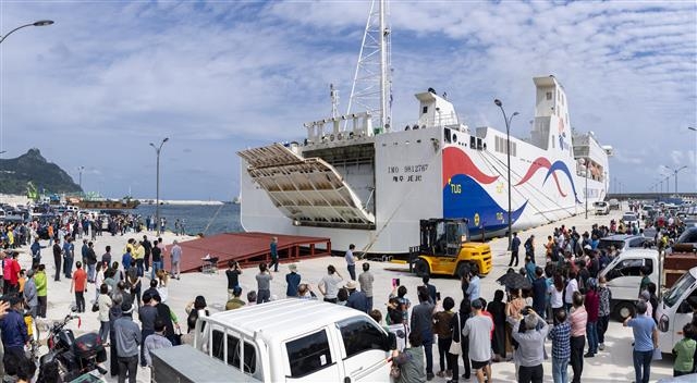 포항 영일만으로 출항하기 위해 울릉도 사동항에 정박 중인 대형 카페리선 ‘뉴씨다오펄호’와 승선을 대기 중인 관광객들. 울릉군 제공