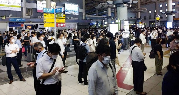 일본 도쿄에서 열차 승객들이 7일 지바현에서 발생한 지진으로 인해  JR 시나가와 역 입구 밖으로 나와 있는 모습. AP 연합뉴스 2021-10-07