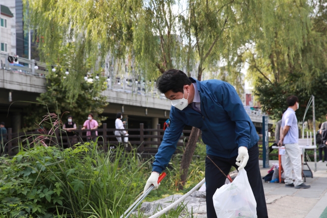 박준희 관악구청장이 14일 오후 강감찬 축제 개막식 식전 행사인 _쓰담쓰담 강감찬 플로깅 SNS 이벤트에 참여해 별빛내린천에 버려진 쓰레기를 줍고 있다. 관악구 제공
