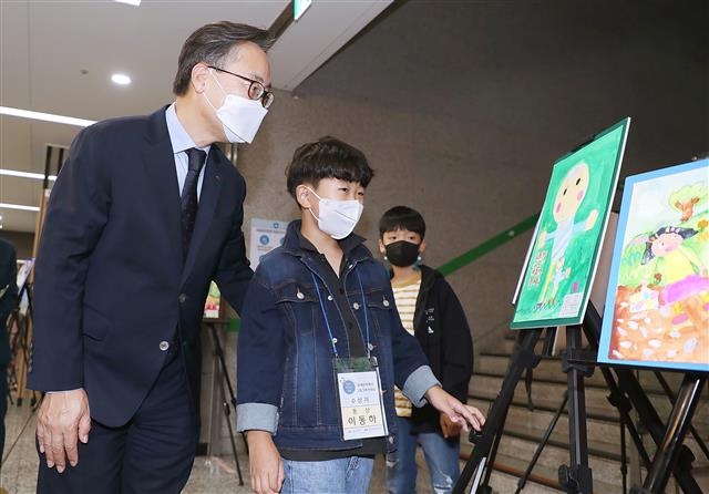 지난 12일 유성훈(왼쪽 첫 번째) 금천구청장이 서울 금나래아트홀에서 열린 장애인의날 행사에 참석해 그림그리기 대회 수상작들을 어린이들과 함께 보고 있다. 해당 작품들은 자리를 옮겨 31일까지 금나래중앙공원, 독산역 등에서 전시된다. 금천구 제공