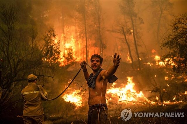 지난 8월 소방관과 주민이 그리스 에비아섬에서 발생한 산불을 끄고 있다. AFP 연합뉴스