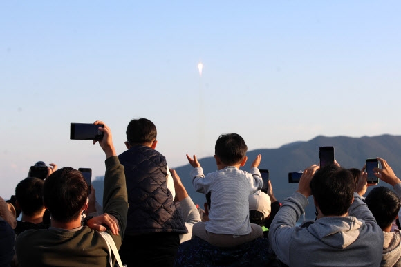 고흥 봉남등대 전망대에서 시민들이 하늘을 향해 날아오르는 누리호를 휴대전화 카메라에 담는 모습. 연합뉴스