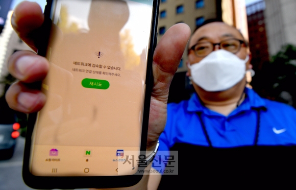 25일 오전 11시20분쯤 KT통신망에 대한 장애가 발생한 가운데 서울의 한 거리에서 시민이 먹통이 된 휴대전화를 들어보이고 있다. 2021.10.25 박지환기자 popocar@seoul.co.kr
