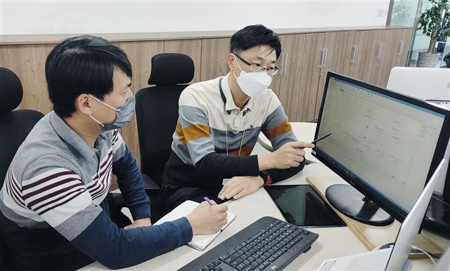 LG전자 관계자(오른쪽)가 협력사 직원에게 로봇프로세스자동화(RPA) 도입과 관련해 노하우를 전수해 주고 있다. LG 제공