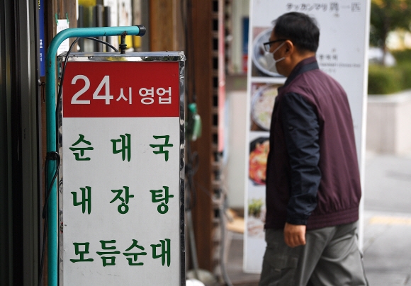 4주간 ‘단계적 일상회복’(위드 코로나) 1단계 계획 시작을 하루 앞둔 31일 서울 시내 한 식당에 ‘24시 영업’ 문구가 적혀 있다. 내일부터 수도권은 10명까지, 비수도권은 12명까지 모일 수 있고, 식당·카페 등 대부분 시설의 영업 제한이 풀려 24시간 영업이 가능해진다. 단, 식당·카페에서는 예방접종을 마치지 않은 사람은 4명까지만 모일 수 있다. 2021.10.31 오장환 기자 5zzang@seoul.co.kr