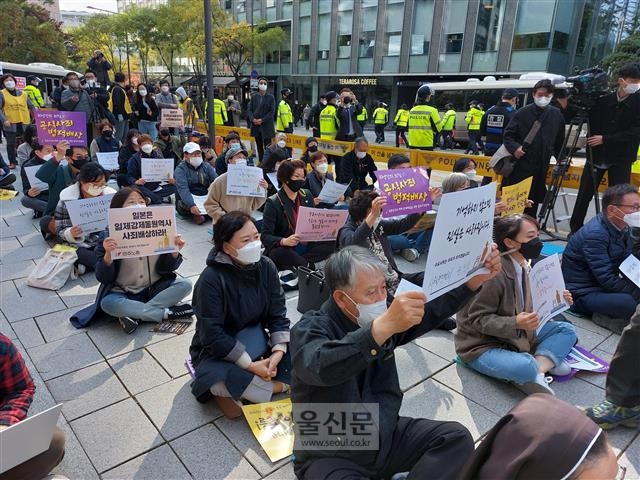 위드 코로나 시행을 계기로 ‘일본군 성노예제 문제해결을 위한 수요집회’가 약 1년 4개월 만에 집회 형태로 열렸다. 3일 서울 종로구 연합뉴스 사옥 앞에서 집회 참여자들이 일본의 사죄와 배상을 요구하는 피켓을 들고 있다.