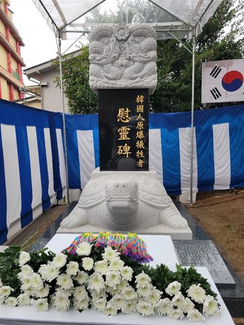 지난 6일 일본 나가사키시 원폭기념관 앞 평화공원에 세워진 한국인 원폭 희생자 위령비 앞에 추모의 종이학 1000마리와 국화가 놓여 있다.