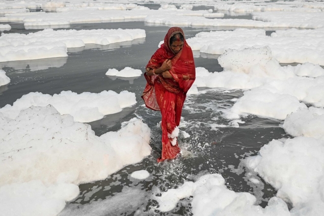 거품으로 가득찬 야무나 강에 몸을 담은 한 여성의 모습. 사진=AFP 연합뉴스