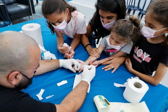 22일(현지시간) 이스라엘 네타냐에서 개학을 앞둔 학생들이 코로나19 항체 검사를 받고 있다. 2021.8.22 네타냐 AFP 연합뉴스
