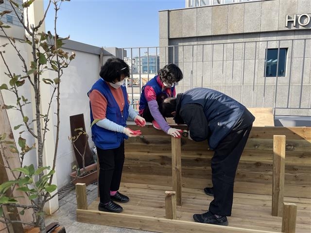 서울 종로구가 ‘2021년 쪽방주민 건강·문화 프로그램’을 운영한다. 사진은 돈의동 쪽방상담소 옥상 공간에 화단을 설치하고 있는 모습. 종로구 제공