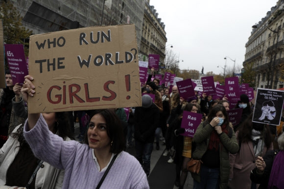 20일(현지시간) 프랑스 파리에서 여성에 대한 폭력에 반대하는 시위가 열린 가운데 한 참가자가 ‘누가 세계를 움직이나? 여자’라고 쓰인 팻말을 든 채 행진하고 있다.