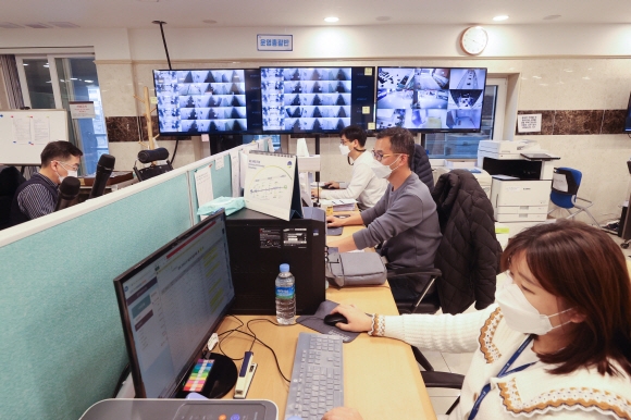 지난 18일 오후 서울 영등포구에 있는 코로나19 생활치료센터 상황실에서 운영총괄반 직원들이 모니터를 보며 실시간 상태를 확인하고 있다. 사진공동취재단