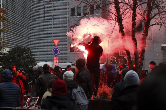 벨기에 정부의 코로나19 규제 재도입에 반대하는 시위대 일부가 21일(현지시간) 수도 브뤼셀에 모여 시위를 벌이다 밤이 되자 과격해져 홍염을 태우고 있다. 브뤼셀 AP 연합뉴스 