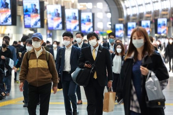 지난 16일 마스크를 쓴 시민들이 일본 도쿄 시나가와 역을 지나고 있다. AP 연합뉴스