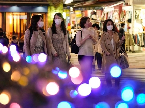 지난 8일 저녁 마스크를 쓴 시민들이 일본 도쿄 시내의 크리스마스 장식물 앞을 지나고 있다. EPA 연합뉴스