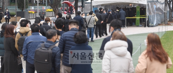 24일 서울시청 광장 선별진료소에 추운 날씨 속에서도 코로나19 검사를 받으려는 시민들이 길게 줄을 지어 서 있다. 박지환 기자 popocar@seoul.co.kr